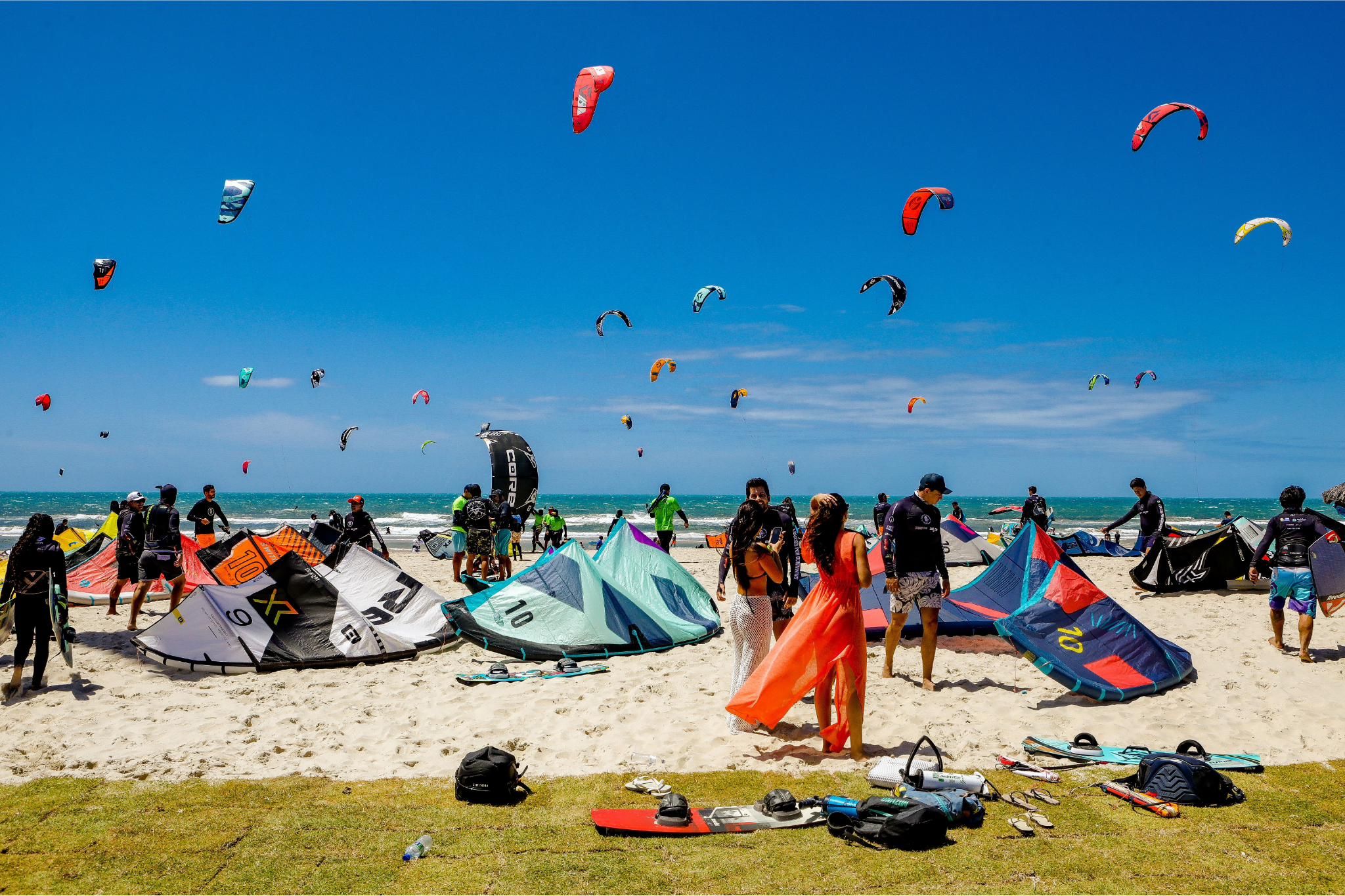 pessoas na praia com material de kitesurf